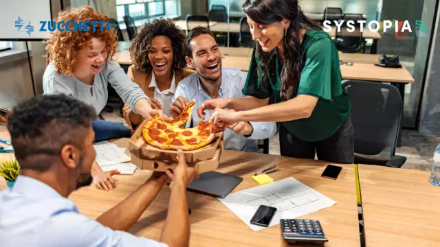 A group of people around a table with a pizza